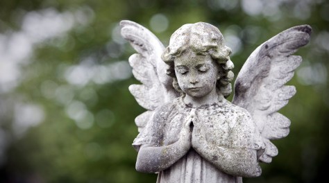 Stone cherub praying